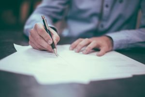 Person reviewing and signing insurance paperwork